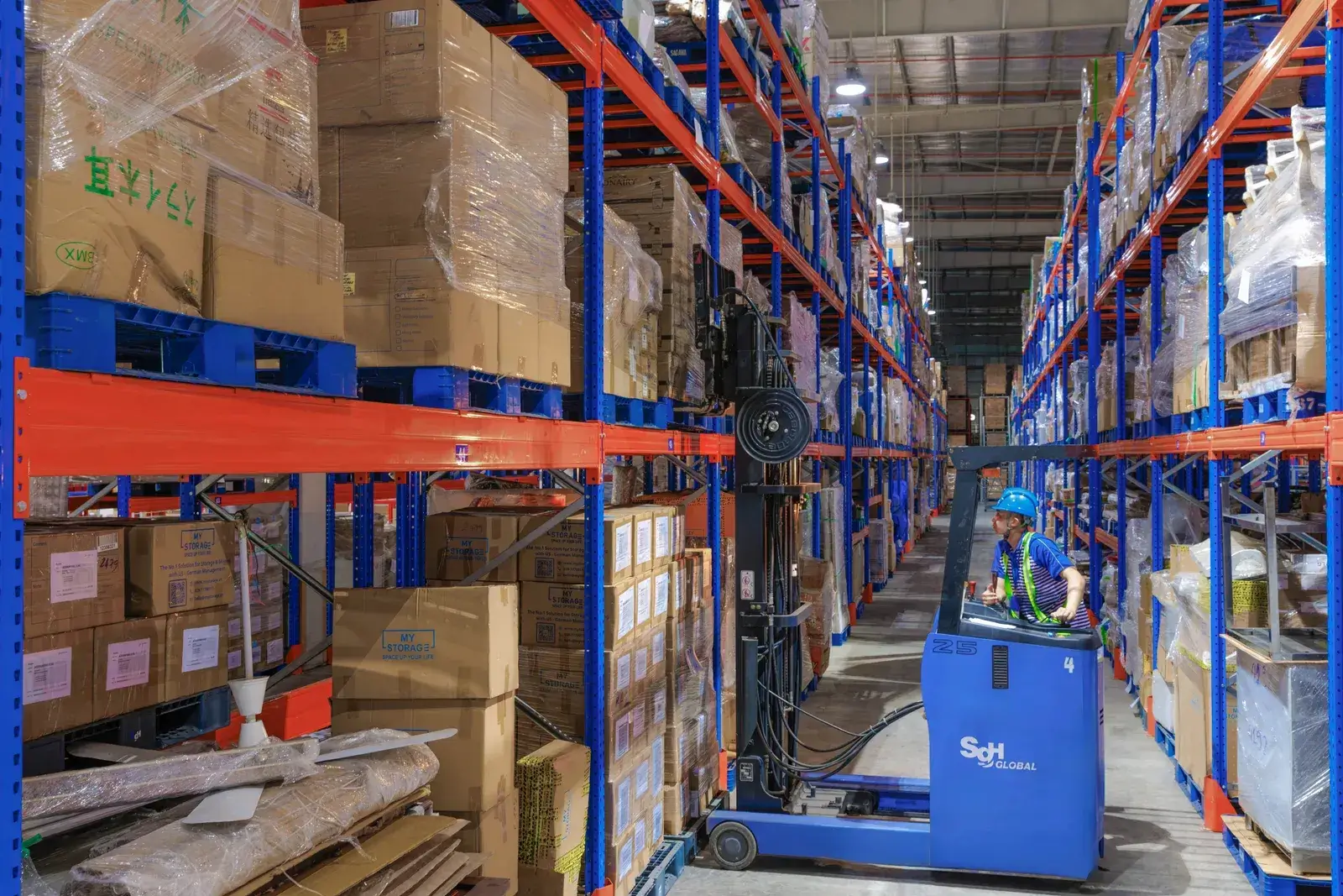Nhân viên vận hành xe nâng giữa các dãy kệ pallet chứa hàng trong kho MyStorage