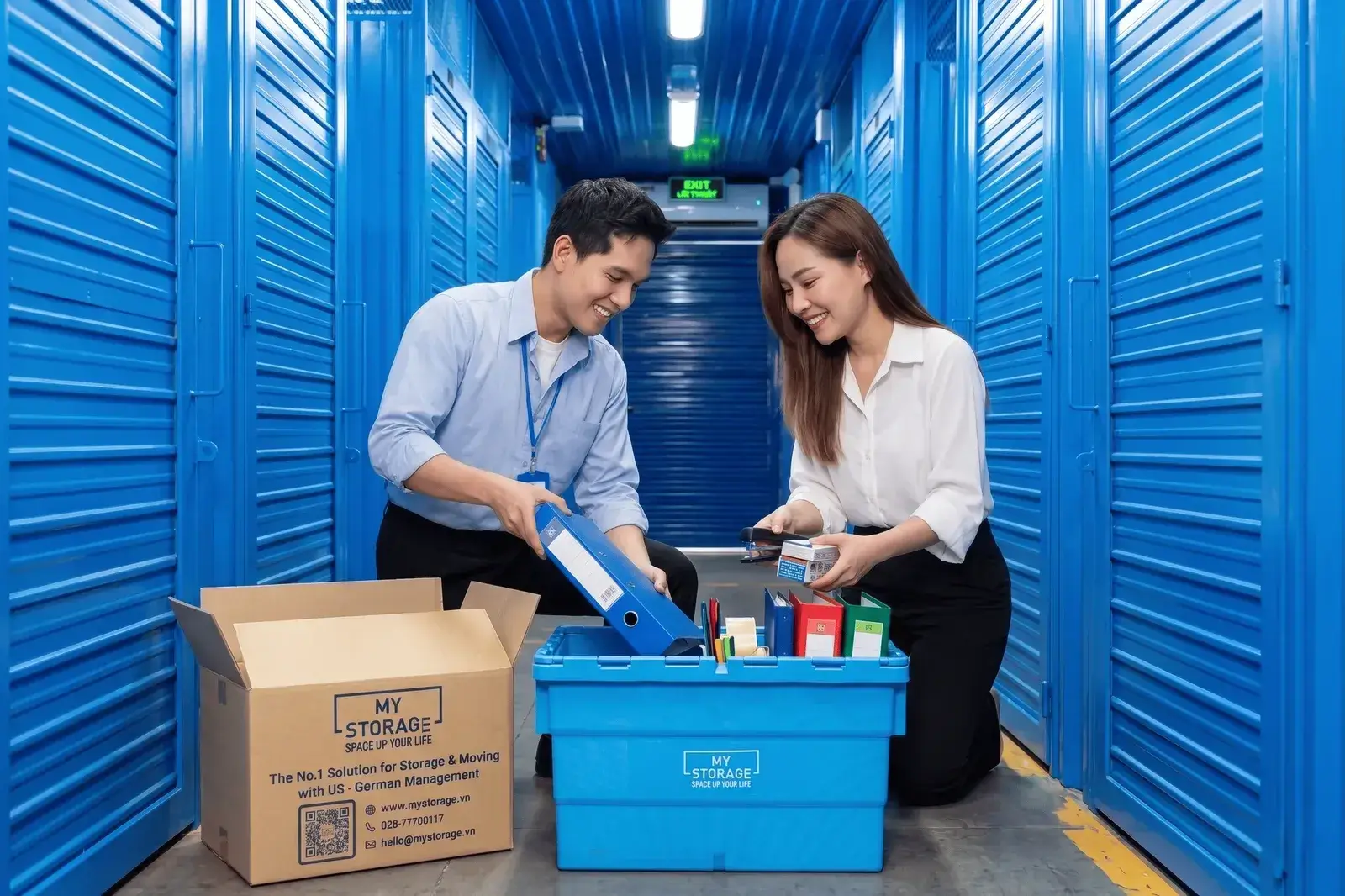Hai người sắp xếp hồ sơ và đồ dùng vào thùng lưu trữ trong kho tự quản MyStorage